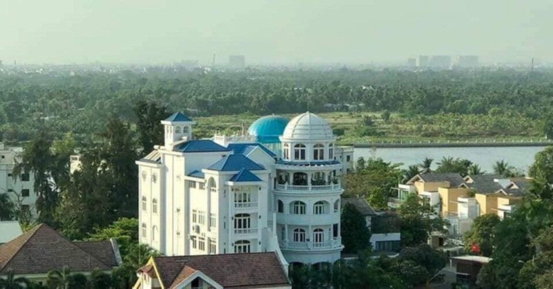 Phía ngoài căn biệt thự với cảnh quan nhiều cây cối.