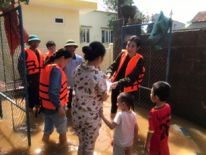 Hoa hậu Việt Nam 2016 Đỗ Mỹ Linh lội nước tới trao quà cho bà con ở Quảng Bình. (Ảnh: Báo Giao Thông).