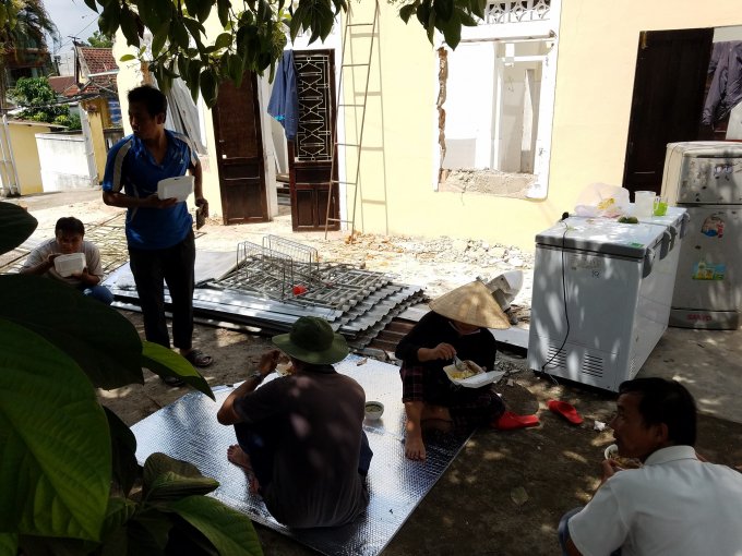 Ngồi nghỉ ngơi sau thời gian tháo dỡ nhà cực nhọc.