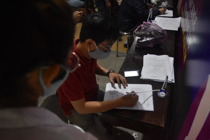 Lực lượng tại chốt kiểm tra hướng dẫn hành khách điền các thông tin vào tờ khai y tế.