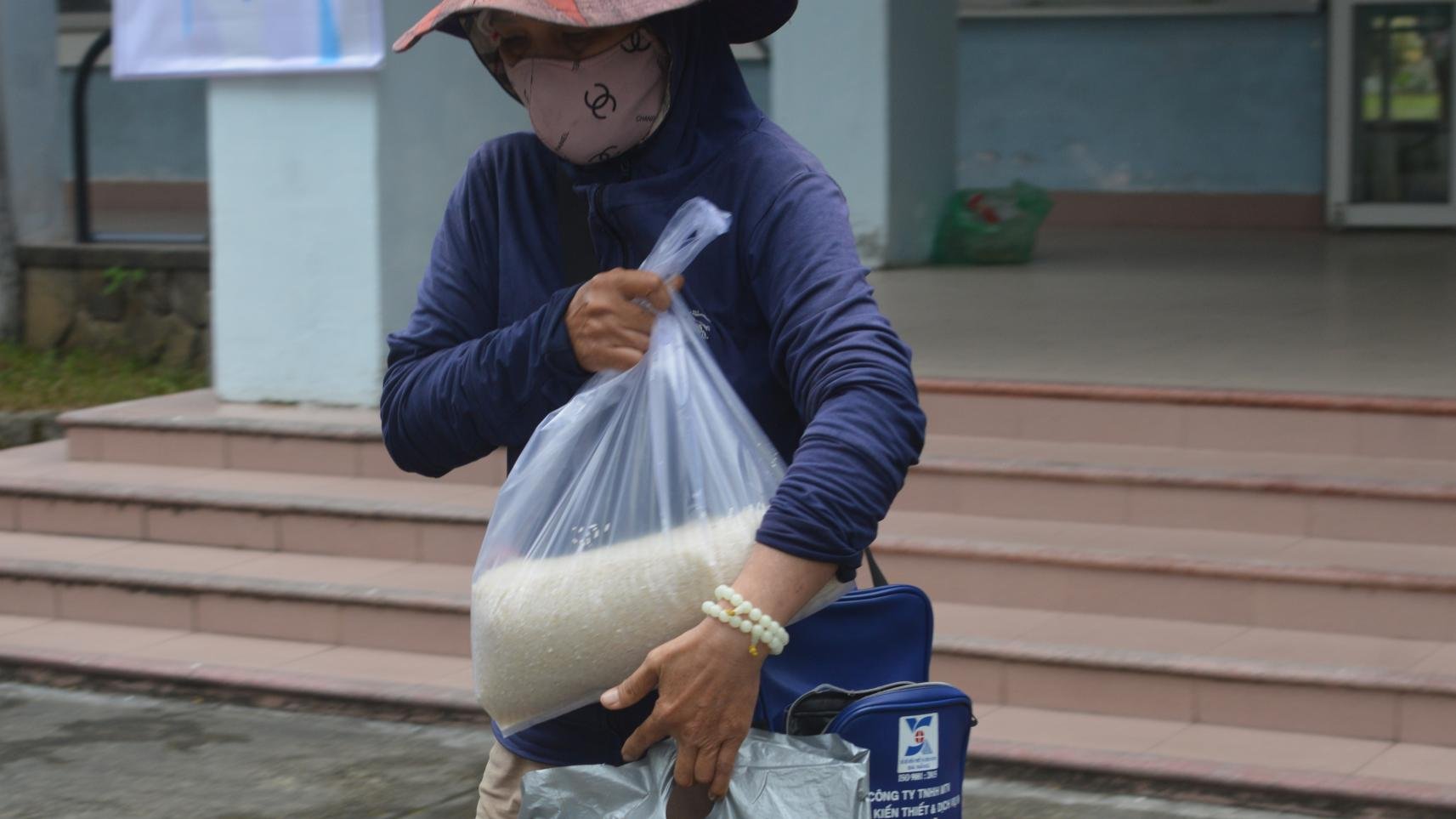 Người dân nhận được gạo sau thời gian xếp hàng.