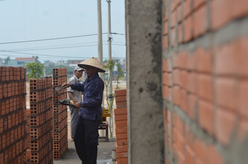 Người thợ chăm chỉ xây dựng “mái ấm” cho các hộ dân Thượng thành. Ảnh: Tuấn Hiệp.