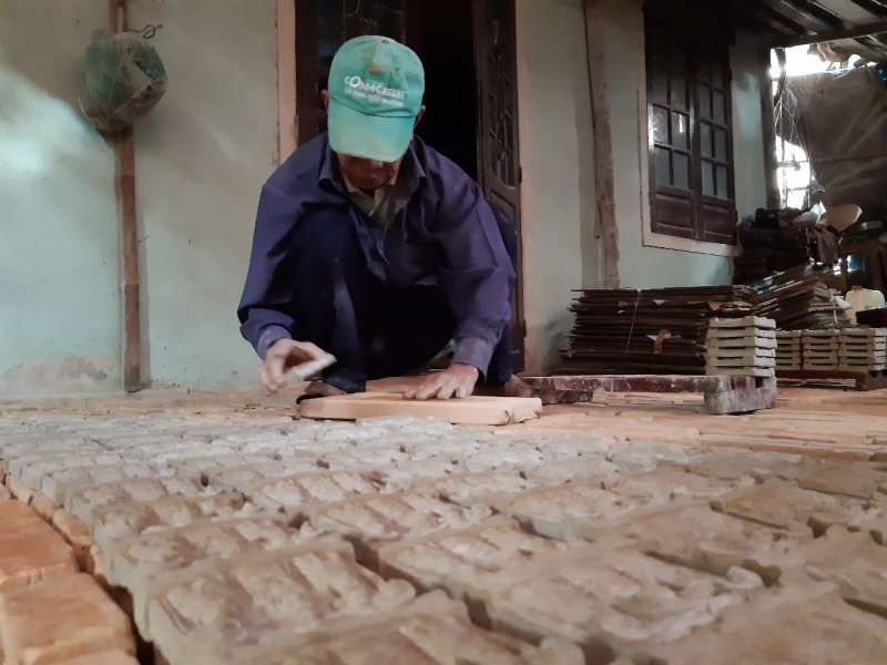 Ông Võ Văn Nhật, 64 tuổi, ngày đêm “biến đất thành cơm”. Một ngày trôi qua, ông tạo ra được hơn 300 tượng ông Táo. “Thời tiết năm nay mưa nhiều khiến việc phơi ông Táo trước khi nung gặp khó khăn. Chúng tôi tận dụng sức nóng từ lò nung để xếp tượng xung quanh sấy khô”, ông Nhật chia sẻ.