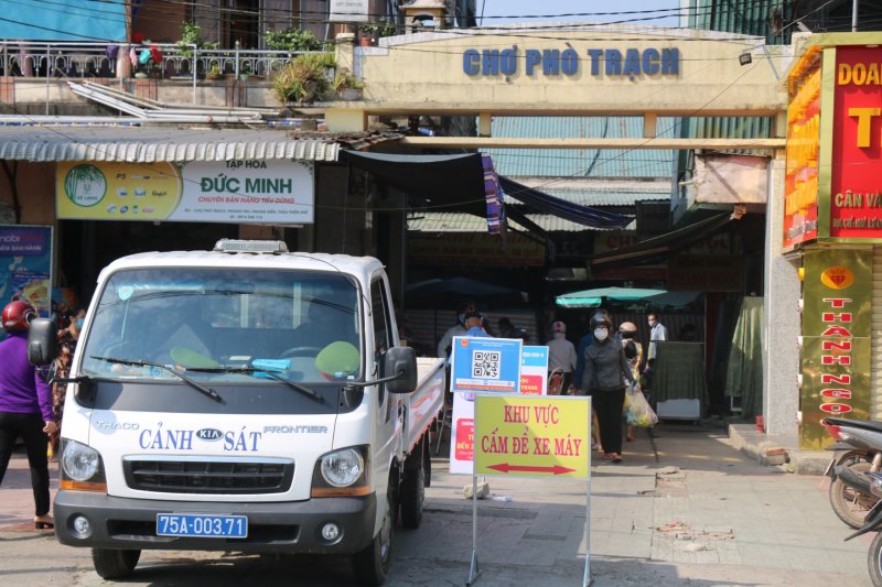 Người dân đến chợ Phò Trạch chấp hành việc mang khẩu trang.