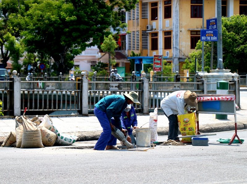 Làm việc vất vả bên đường giữa tiết trời nắng nóng.