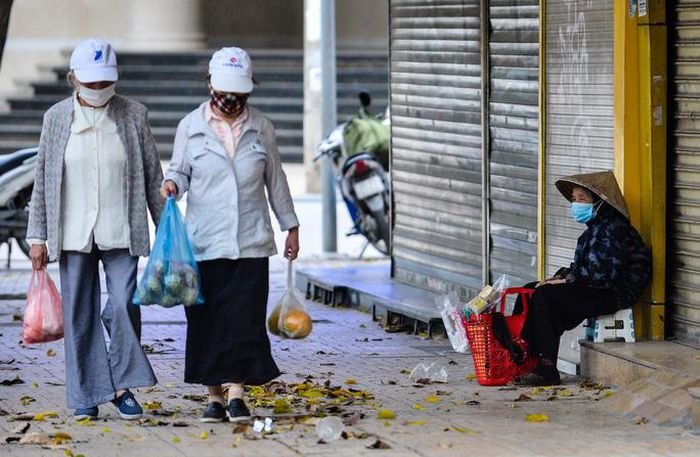 Người dân khoác thêm áo ấm khi ra đường, nhất là những người cao tuổi. Ảnh: NLĐ.