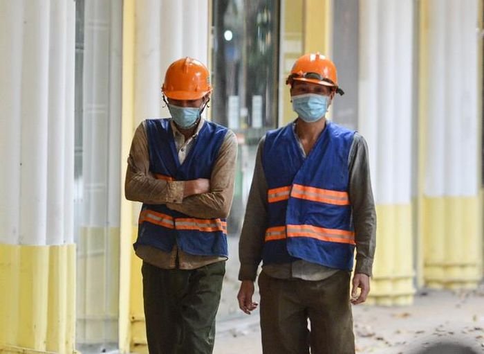 Những công nhân cảm nhận rõ cái lạnh đầu mùa trong bộ quần áo mỏng trên đường đi làm. Ảnh: NLĐ.