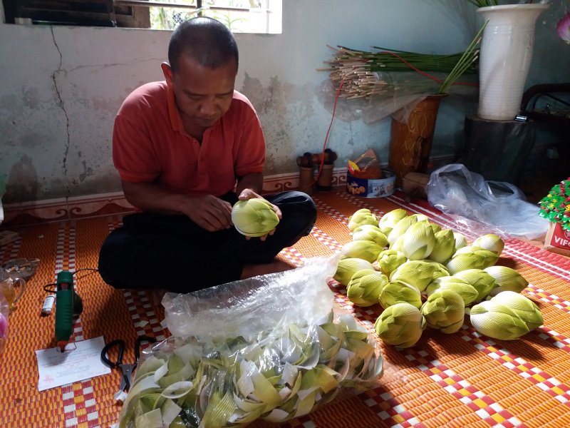Con của ông Hóa làm hoa sen giấy.