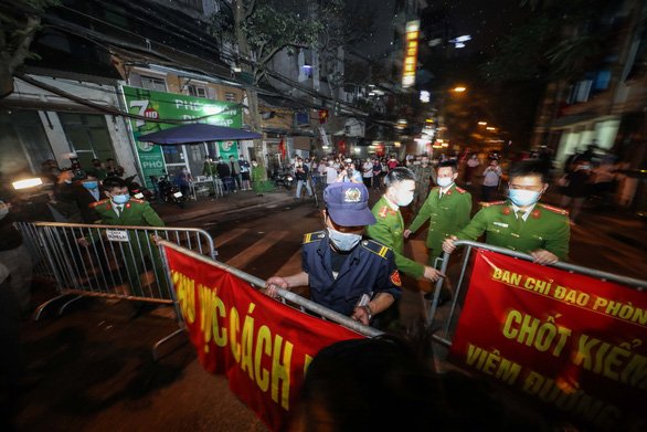 Đúng 21h10, công an phường Trúc Bạch gỡ rào chắn trong tiếng reo hò của người dân. Ảnh: Tuổi trẻ.