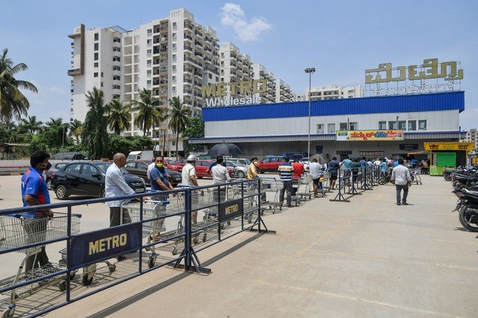 Mọi người phải giữ khoảng cách khi đi mua nhu yếu phẩm.