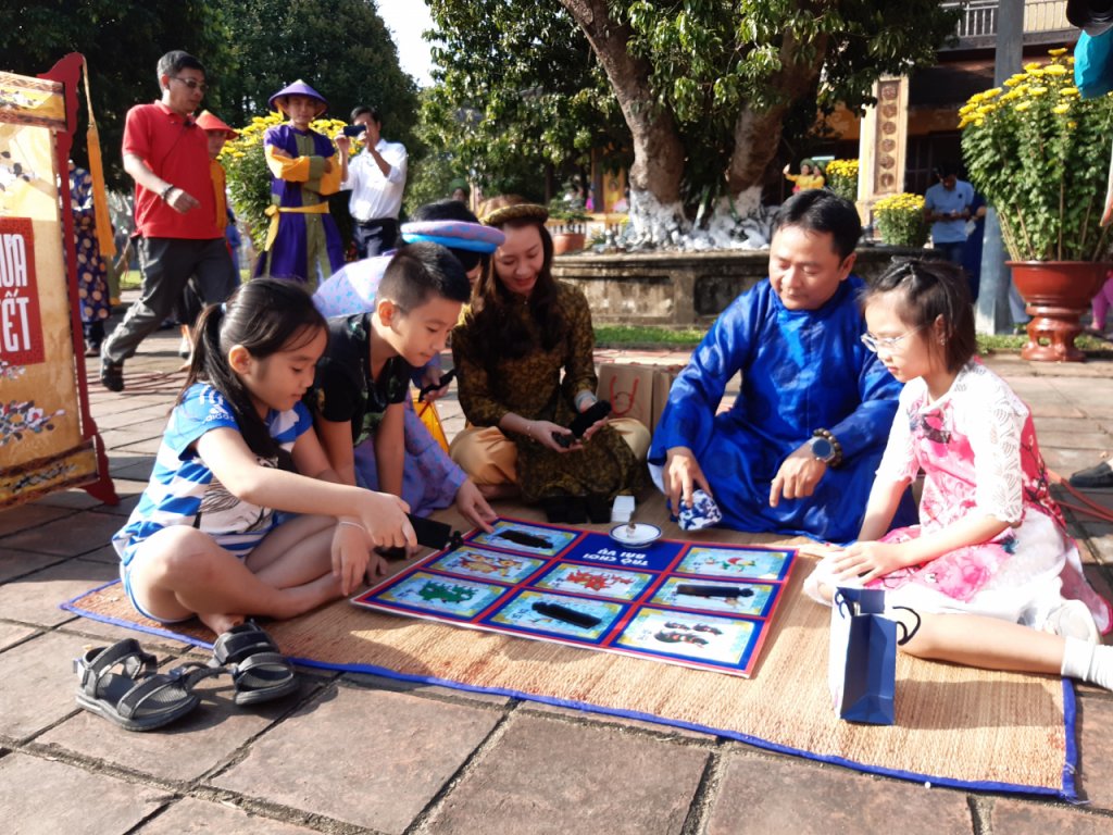 Trên mặt bàn có tám con vật gồm lợn đen, voi trắng, trâu xanh, ếch vàng, ngựa đỏ, rùa vàng, tôm xanh, cá vàng.