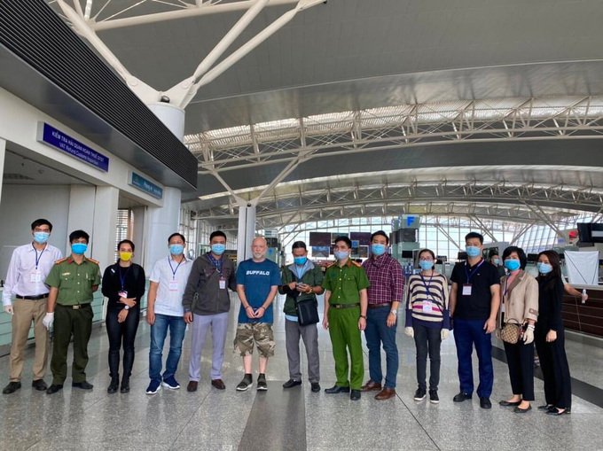 Wade Astle (áo xanh) bị dẫn độ tai sân bay. Ảnh: Công an cung cấp