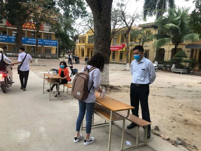 Từng học sinh được thầy cô đo thân nhiệt tại cổng trường rồi sát khuẩn tay trước khi lên lớp.