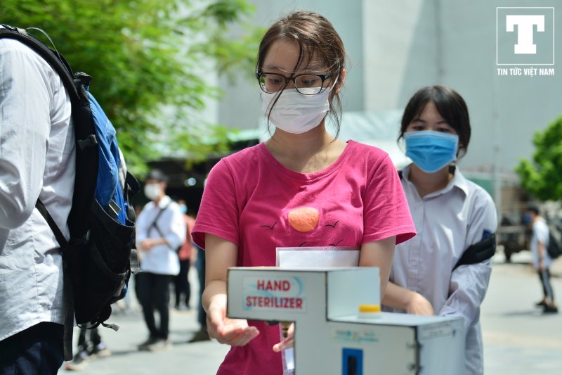 Trước khi vào phòng thi các nữ sinh thực hiện việc rửa tay sát khuẩn, đo thân nhiệt...