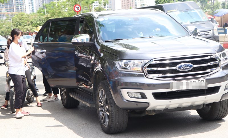 Từng dòng xe ô tô nối đuôi nhau, lực lượng bảo vệ đứng hướng dẫn, đảm bảo an ninh.