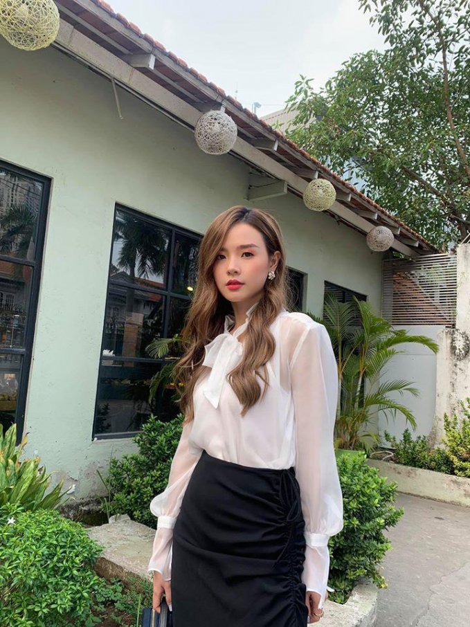 Đồng điệu trong phong cách thanh lịch, Midu cũng lựa chọn sơmi nhưng là kiểu áo thắt nơ kiêu kì hóa cô tiểu thư xinh đẹp.