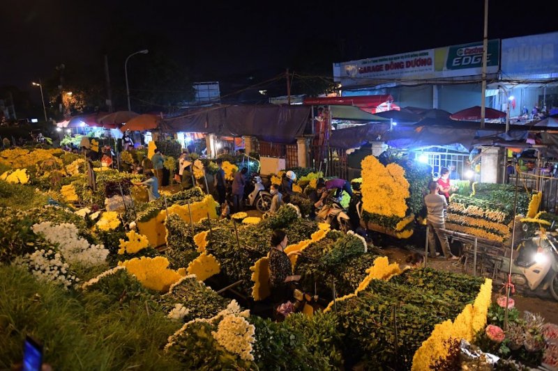 Những chuyến xe chất đầy hàng hóa nối đuôi nhau ra cổng chợ.
