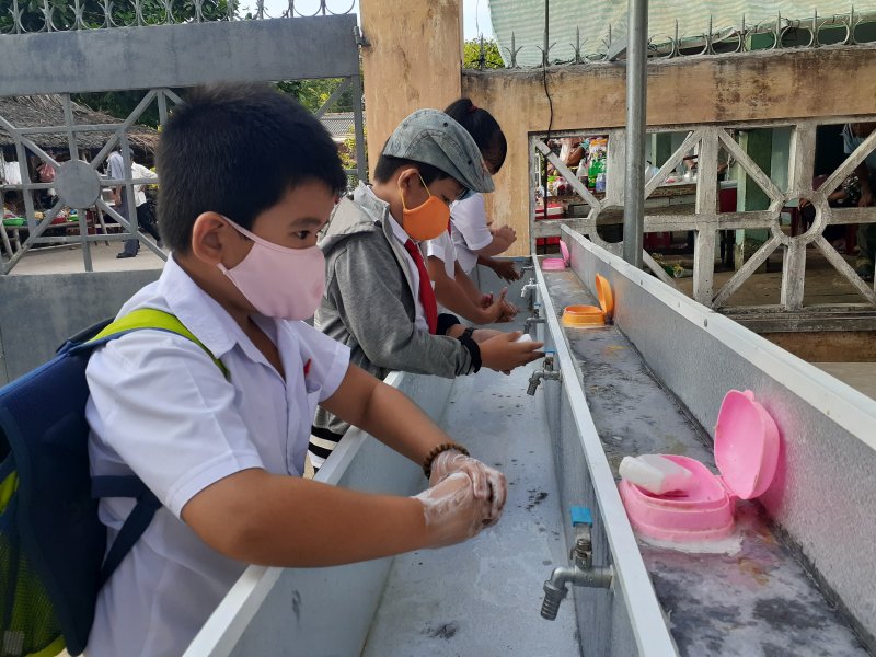 : Học sinh được hướng dẫn đeo khẩu trang ở nơi đông người và rửa tay trước khi vào lớp học