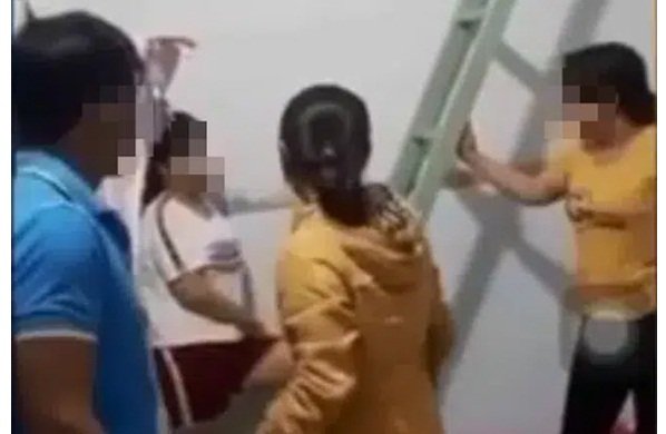 Cô vợ mặc áo vàng cộc tay đứng bên phải, cô bồ áo trắng đứng dựa tường (Ảnh cắt từ clip)