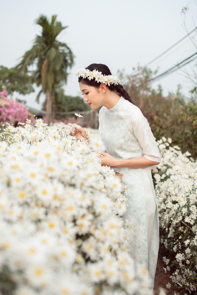 Thanh Tú mặc trang phục nằm trong BST áo dài Hương đồng nội của Hoa hậu Ngọc Hân lấy cảm hứng từ hình ảnh những bông hoa cúc họa mi dịu dàng, thanh khiết. Đây cũng là lựa chọn rất thích hợp cho các nàng muốn xây dựng hình ảnh dịu dàng bên cúc họa mi.
